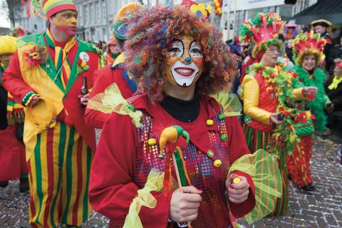 Vrouw verkleed als clown tijdens carnavalstoet